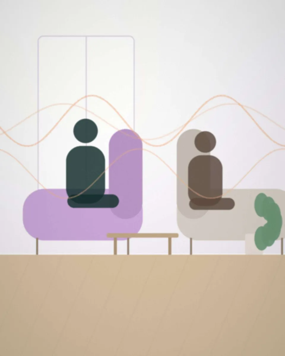 Une psychologue écoute une personne assise face à elle, dans un bureau calme et lumineux, vue de dos