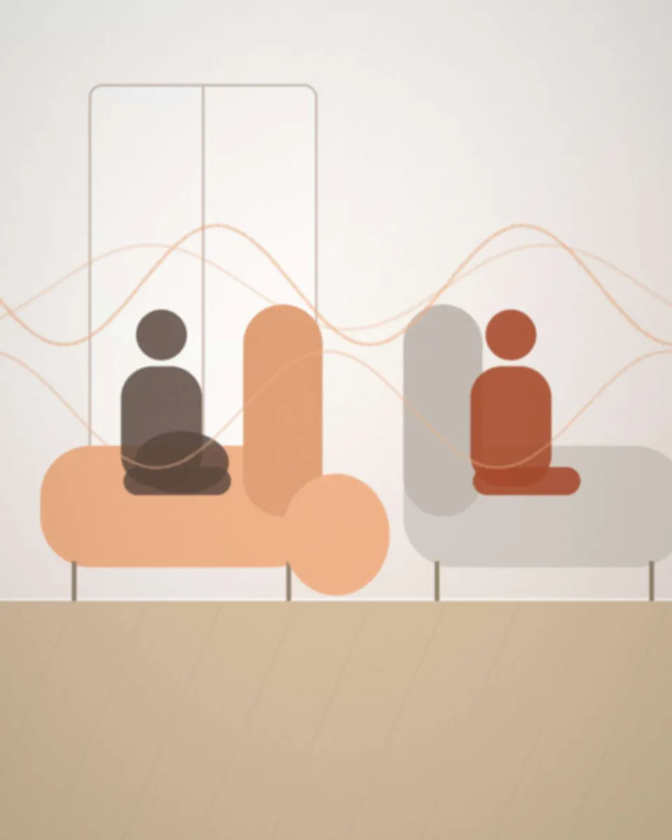 Une sage-femme échange avec une femme enceinte assise dans un fauteuil, vue de dos, dans un cabinet lumineux
