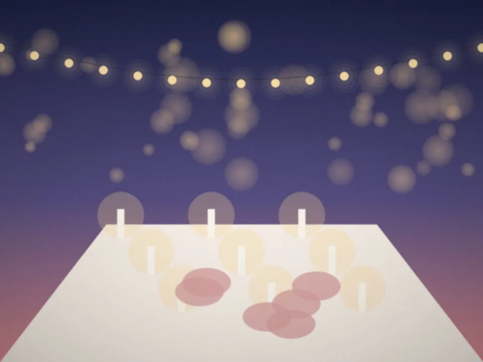 Longue table de mariage dressée sous une guirlande lumineuse