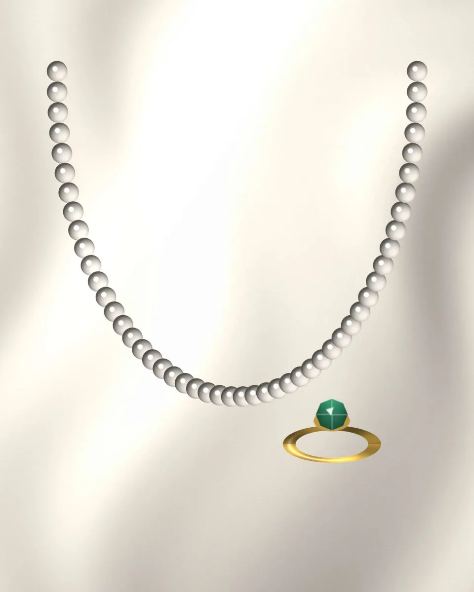 Rang de perles porté sur un col clair, bague à la main