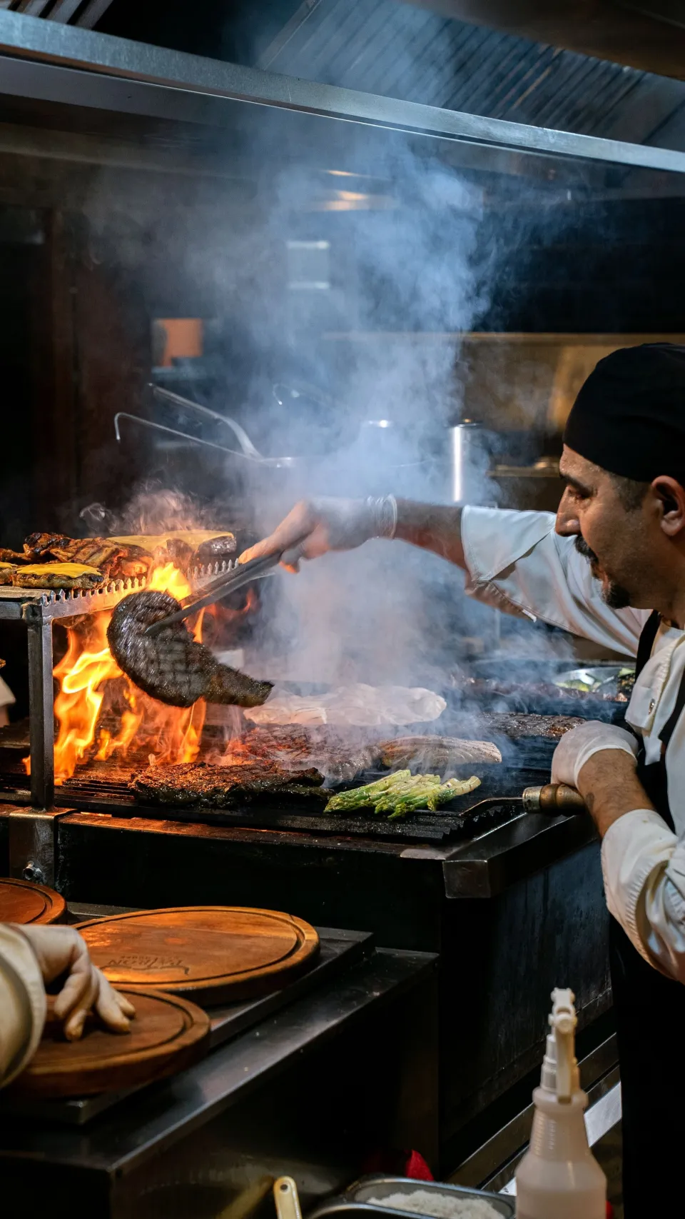 Le chef au grill, flammes et fumée