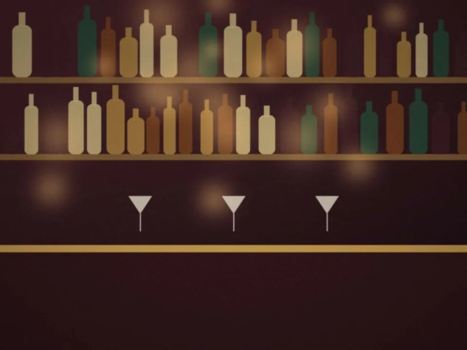 Le bar du hall le soir : étagères de bouteilles et lumières douces