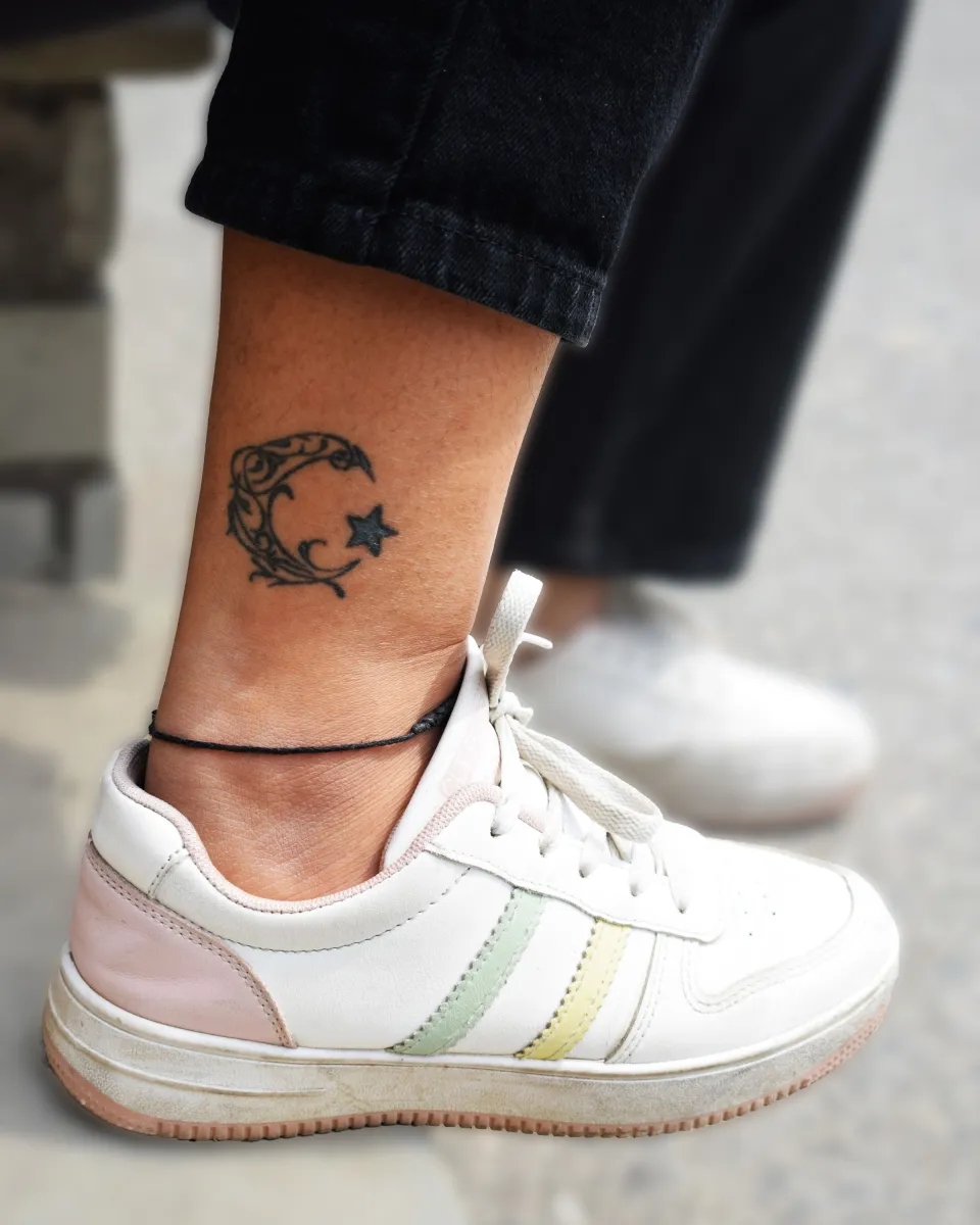 Tatouage fine line « Cercles et constellation » sur cheville, réalisé par Lou