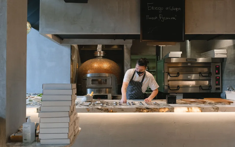 La salle le soir : carreaux verts, petites tables et suspensions