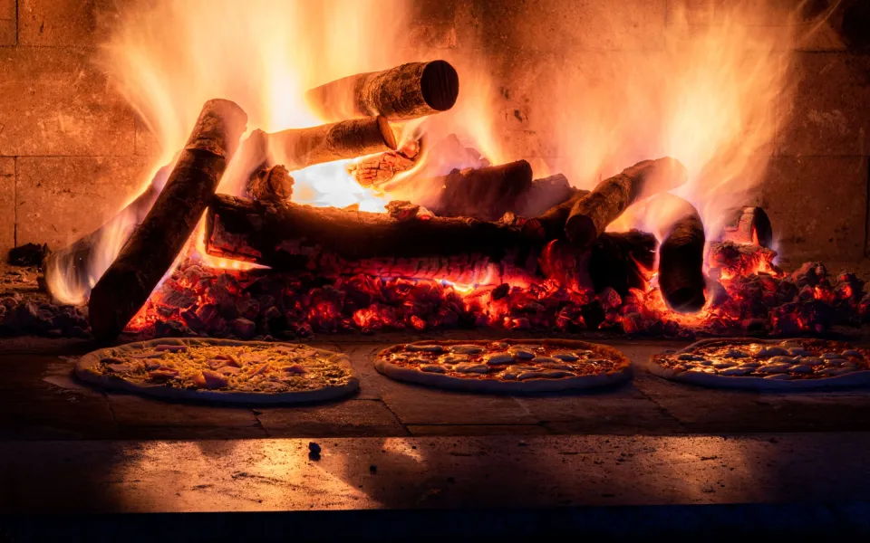 Le four à bois en briques, flammes au fond de la voûte