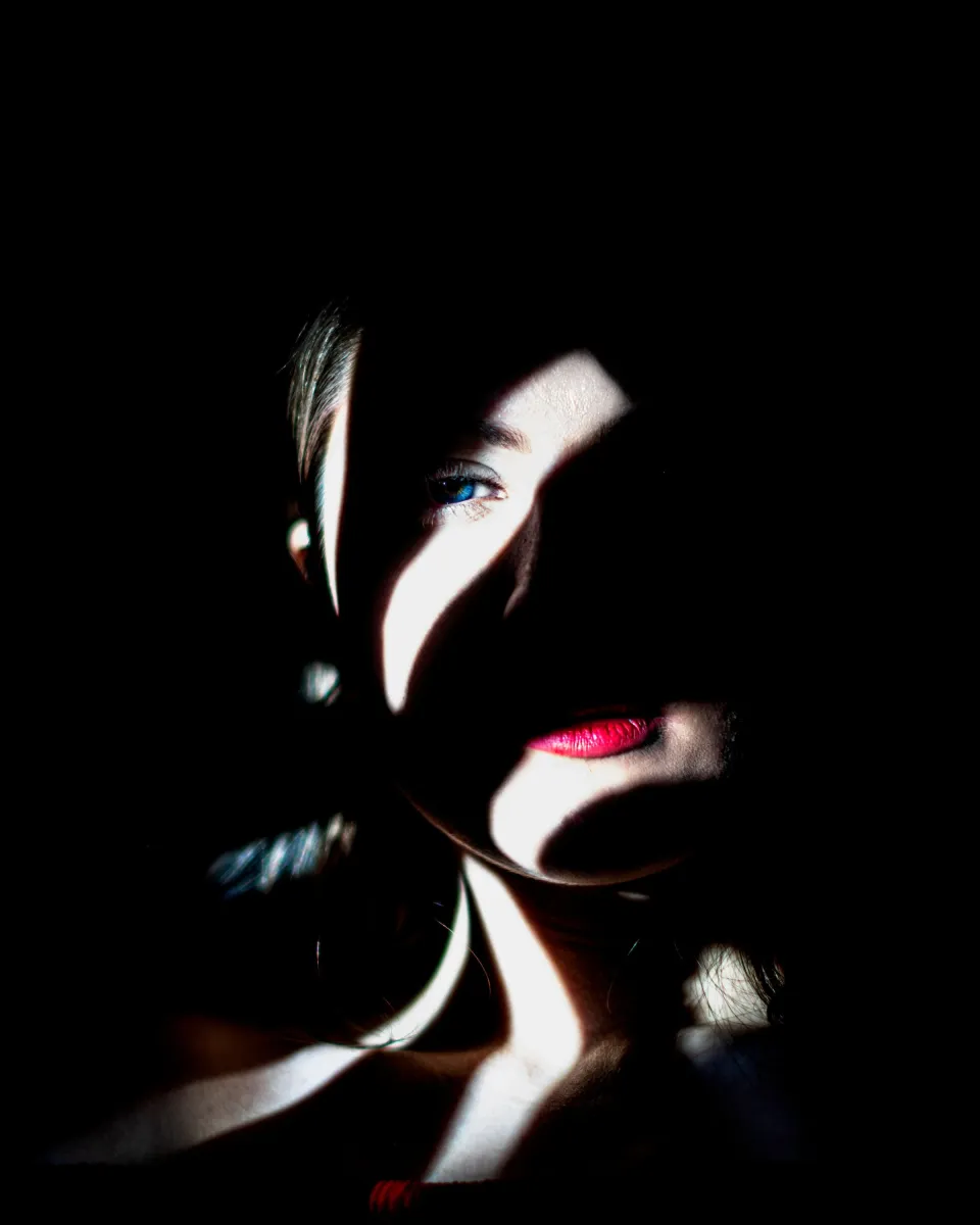 Portrait en clair-obscur sur fond sombre, lumière de fenêtre