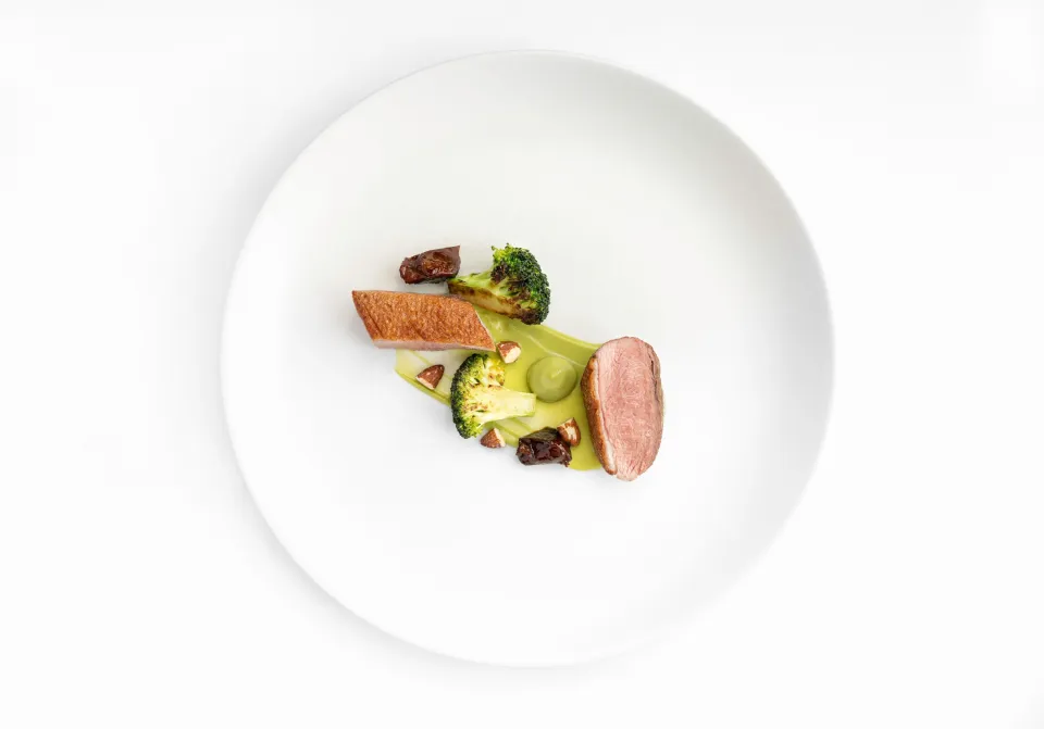 Assiette du menu Saison, dressage minimaliste sur porcelaine blanche